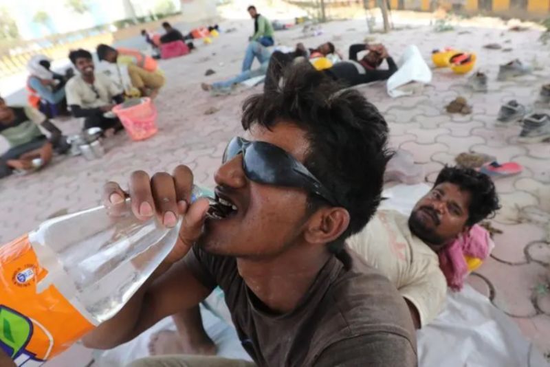 Seorang pekerja konstruksi sedang minum di tengah gelombang panas yang terjadi di Delhi.