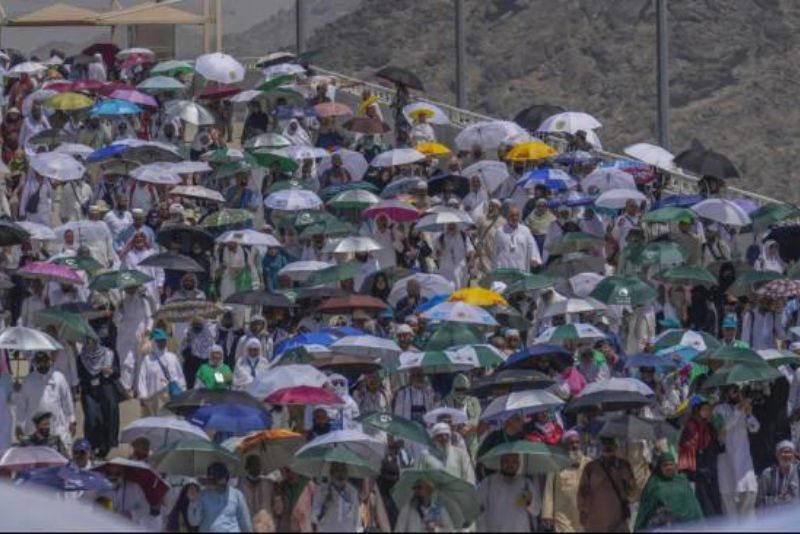 Ratusan jemaah haji tampak menggunakan payung untuk melindungi diri dari sengatan panas sinar matahari di Mina, Arab Saudi