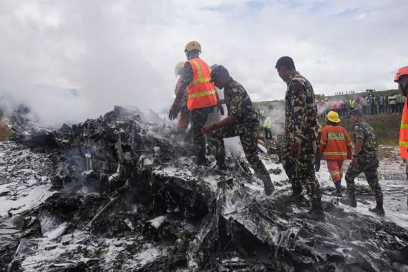 Tim penyelamat dan personel militer berdiri di lokasi reruntuhan pesawat Saurya Airlines