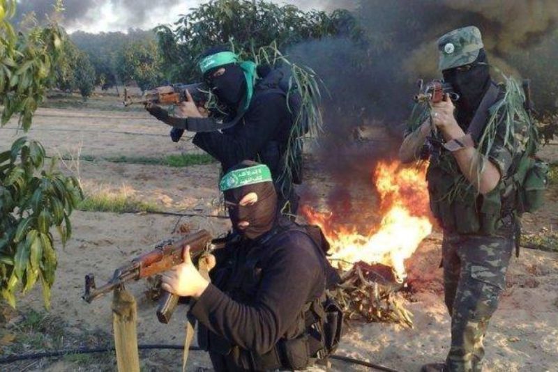 Para petempur Brigade Al-Qassam, sayap militer gerakan pembebasan Palestina mengenakan topeng dan menggenggam senapan serbu