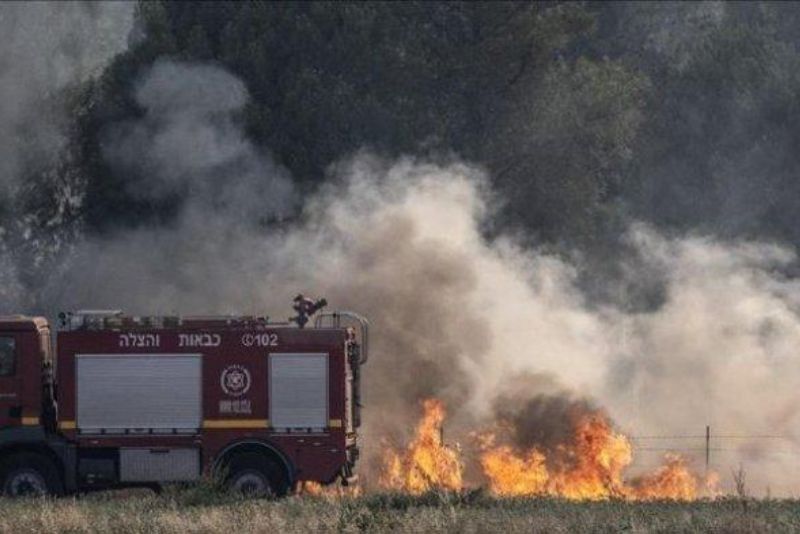 Petugas Pemadam Kebakaran Israel memadamkan api yang berkobar di Dataran Tinggi Golan, wilayah pendudukan Israel setelah serangan roket dari Suriah. Iran turun tangan karena Israel menyebut Hizbullah