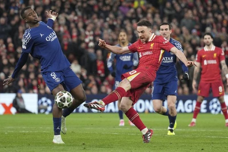 Penyerang Liverpool, Diogo Jota mencoba melepas tembakan yang coba dihentikan bek PSG, Willian Pacho di Anfield. (c) AP Photo/Jon Super