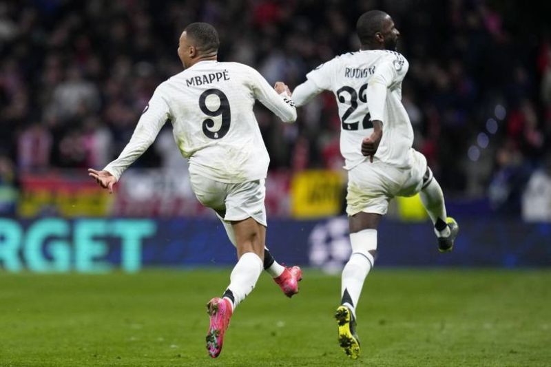 Kylian Mbappe dan Antonio Rudiger merayakan kemenangan Real Madrid usai adu penalti dalam laga Liga Champions kontra Atletico Madrid, Kamis (13/3/2025) dini hari WIB. (c) AP Photo/Manu Fernandez