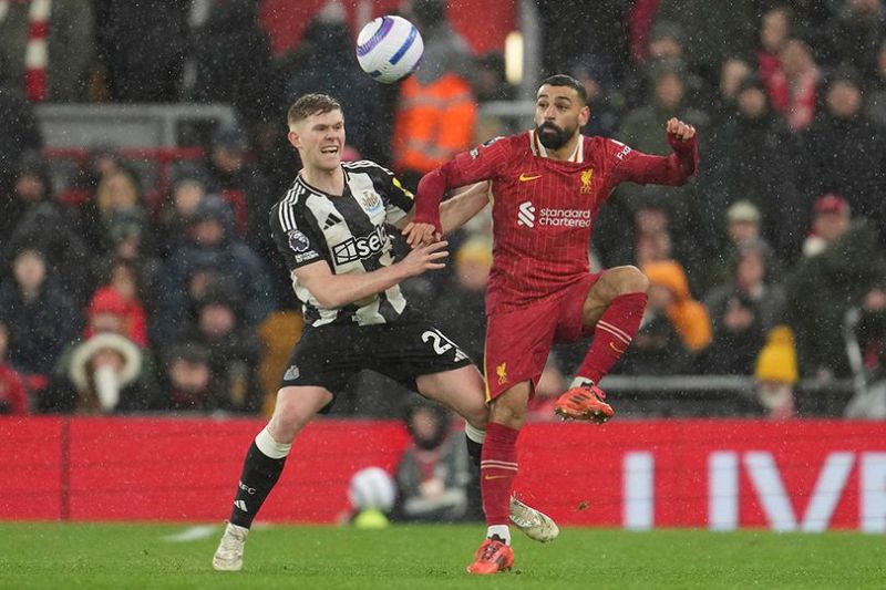 Mohamed Salah berduel dengan lawan di laga Liverpool vs Newcastle, Premier League 2024/2025 (c) AP Photo/Jon Super