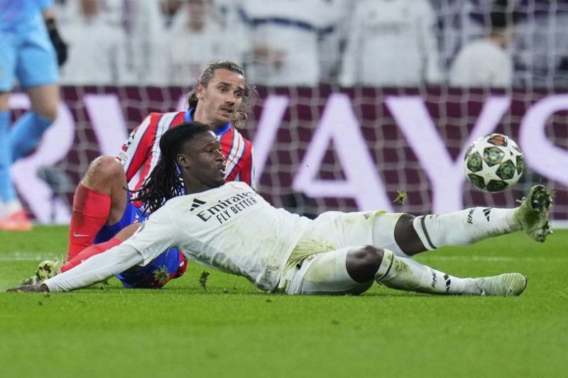 Gelandang Real Madrid Eduardo Camavinga dan penyerang Atletico Madrid Antoine Griezmann dalam laga leg pertama babak 16 besar Liga Champions, Rabu (5/3/2025). (c) AP Photo/Manu Fernandez