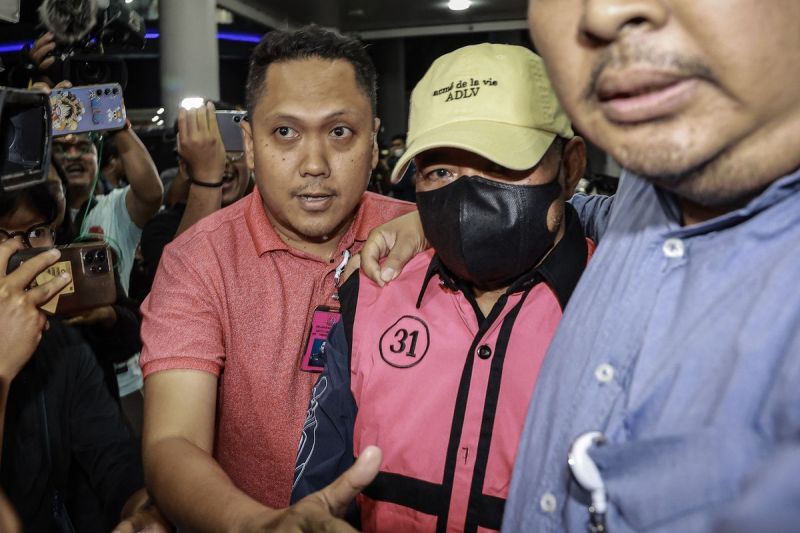 Hakim Pengadilan Negeri (PN) Jakarta Pusat Djuyamto (tengah) dikawal petugas menuju mobil tahanan usai menjalani pemeriksaan di Gedung Kejaksaan Agung, Jakarta, Senin (14/4/2025).