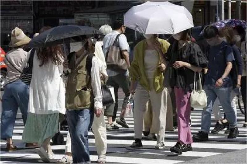 warga Jepang berjalan di tengah panas ekstrem mengenakan payung dan masker pelindung