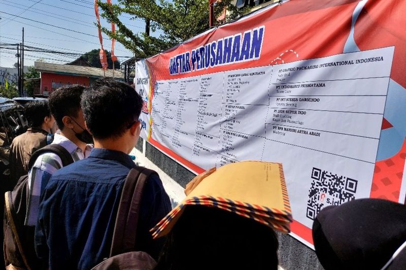 Seorang pencari kerja menggunakan berkas lamaran untuk melindungi kepalanya dari panas saat melihat daftar perusahaan di Job Fair Kabupaten Semarang, Rabu (17/7/2024).(KOMPAS.com/Dian Ade Permana)