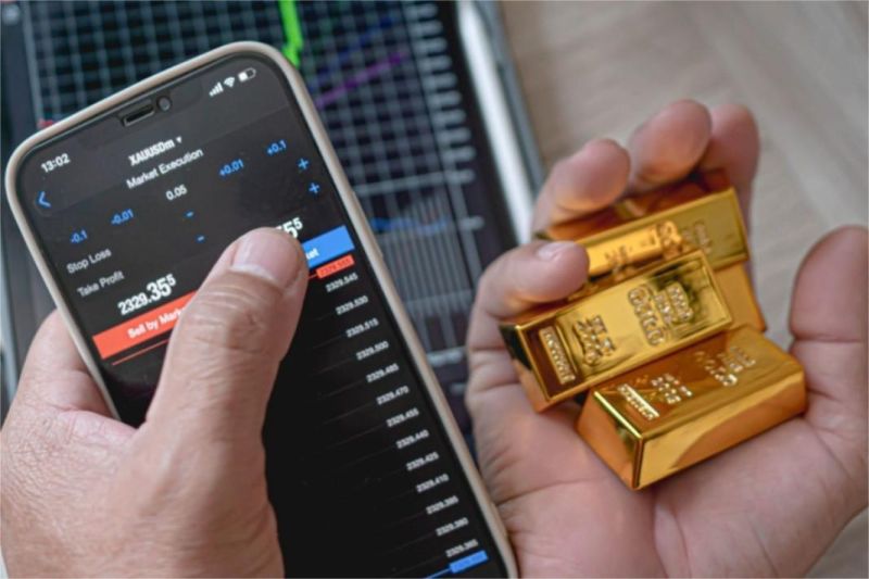 anak muda melihat grafik investasi emas di layar smartphone