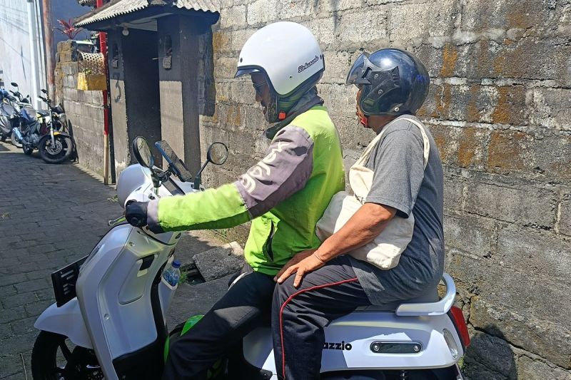 Pengemudi ojek online saat mengantar penumpang di Denpasar, Selasa (20/5/2025).(KOMPAS.com/NI KETUT SUDIANI)