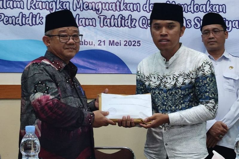 Menteri Pendidikan Dasar dan Menengah Abdul Mu'ti (kiri) memberikan uang santunan kepada perwakilan ahli waris 13 guru SD IT As Syafi'iyah yang mengalami kecelakaan di Kalijambe, Purworejo.