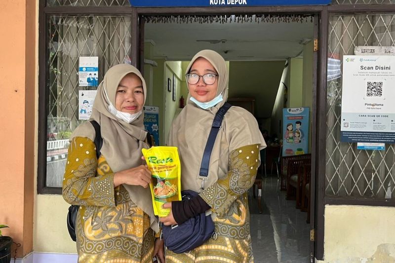 Sana (49), warga asal Grogol, Limo, Kota Depok, setelah menukar minyak jelantah ke minyak goreng di Balai Kota, Rabu (21/5/2025).(KOMPAS.com/DINDA AULIA RAMADHANTY)