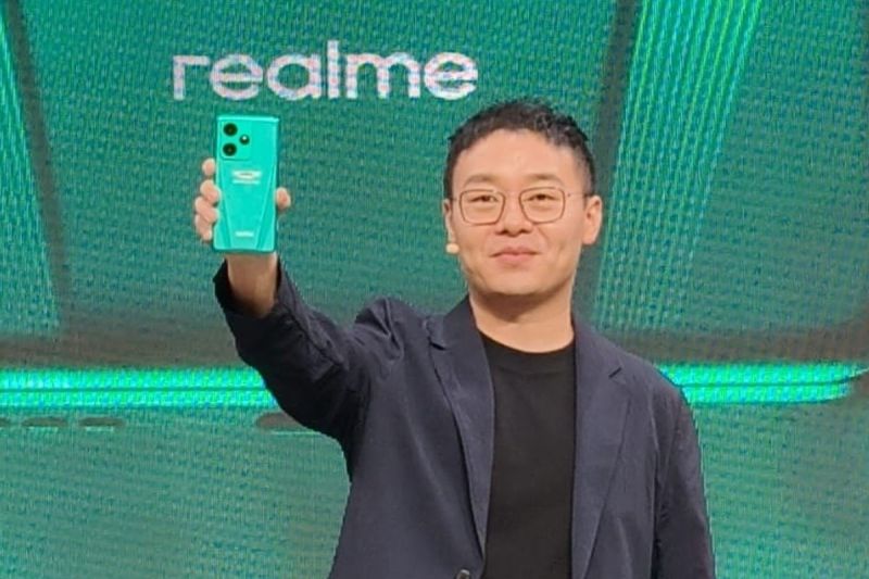 Chase Xu, Vice President dan CMO Realme menunjukkan ponsel Realme GT7 Dream Edition kolaborasi dengan tim F1 Aston Martin Aramco.(KOMPAS.com/Reska K. Nistanto.)