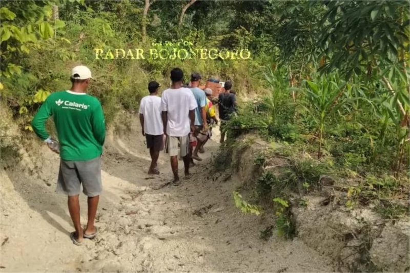 jalan rusak di daerah terpencil dengan warga berjalan kaki melewati genangan