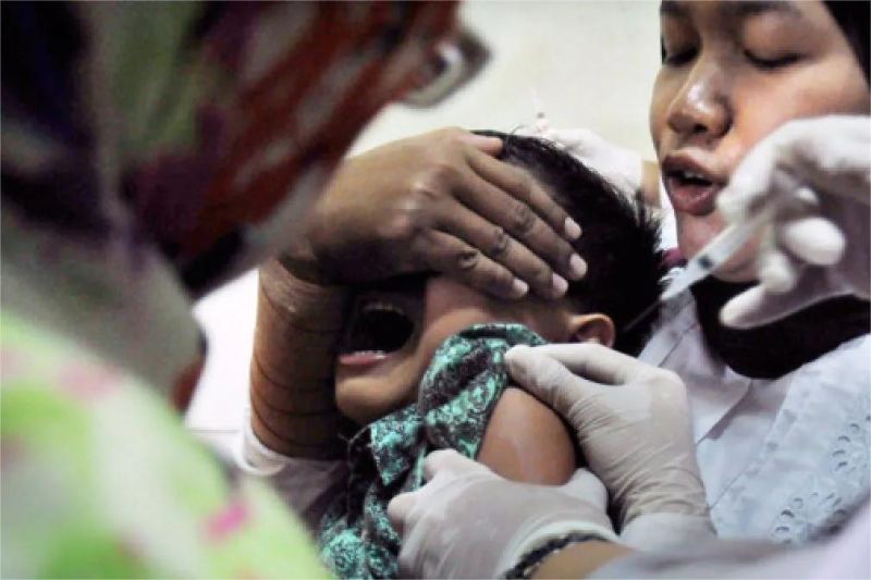 petugas kesehatan memberikan vaksinasi kepada anak di daerah terpencil