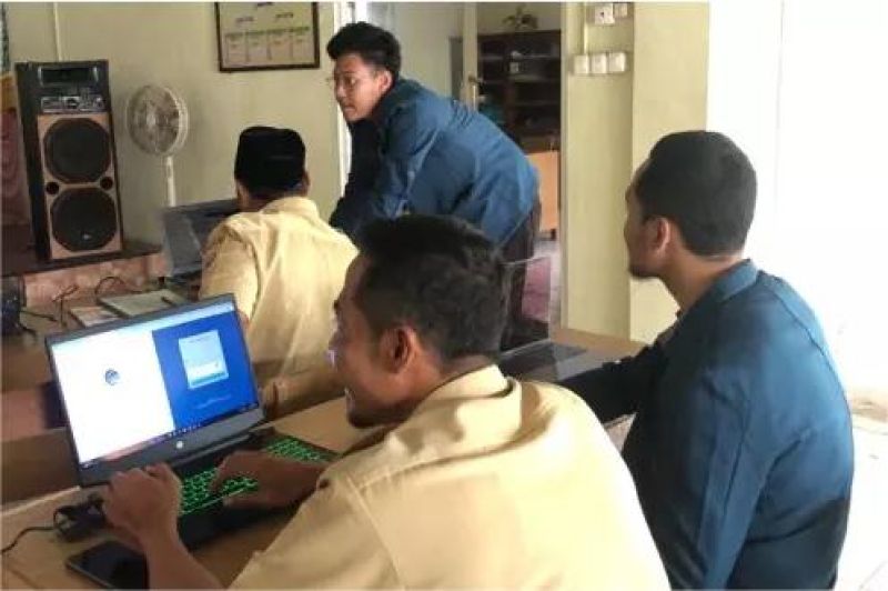 warga desa mengikuti pelatihan digital dengan perangkat komputer di balai desa