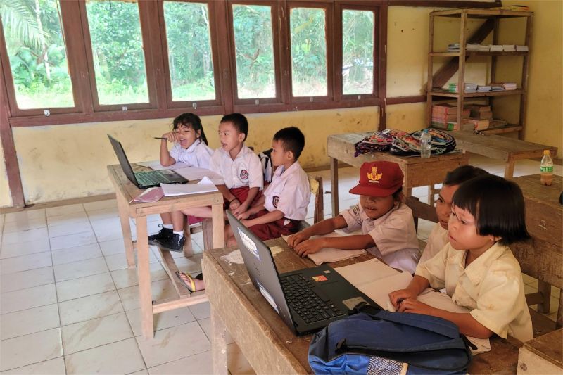 siswa dan guru di sekolah daerah terpencil sedang belajar dengan fasilitas komputer