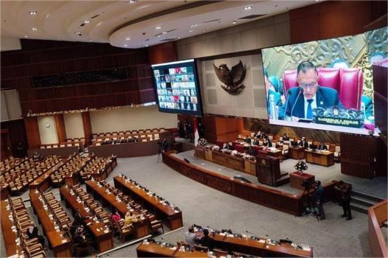 ilustrasi sidang DPR dengan banner RUU Perlindungan Data Pribadi di latar belakang