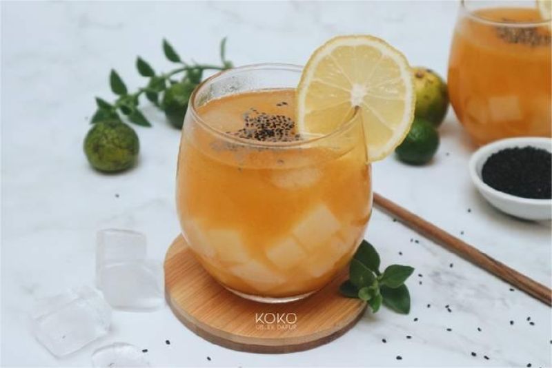 Segelas minuman es jeruk segar dengan es batu dan daun mint
