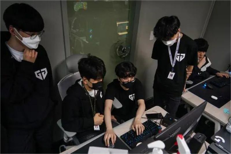 siswa sekolah belajar esports di kelas, dengan laptop dan pelatih game profesional