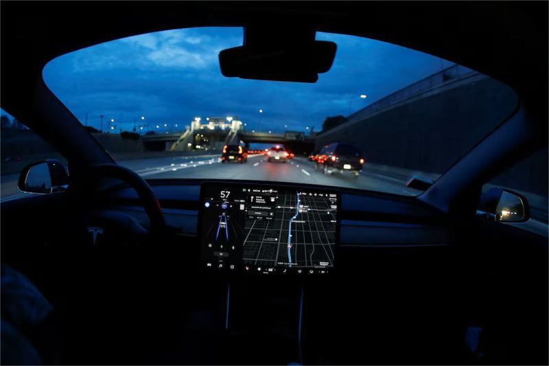 ilustrasi mobil Tesla yang sedang menggunakan fitur autopilot terbaru di jalan raya