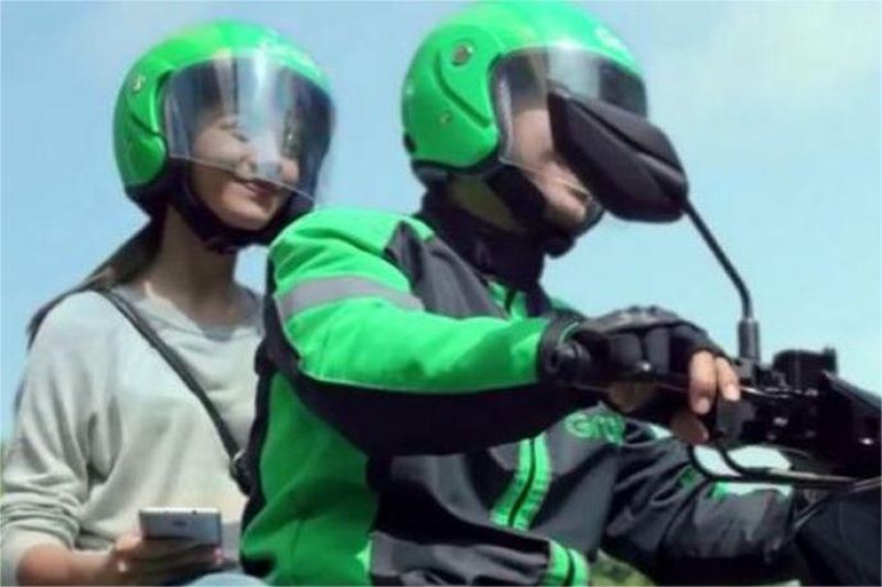 ilustrasi pengemudi ojek online menggunakan helm dan perangkat keselamatan