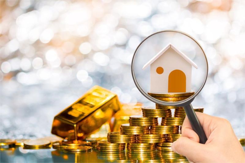 ilustrasi perbandingan investasi emas dan properti dengan simbol koin dan rumah