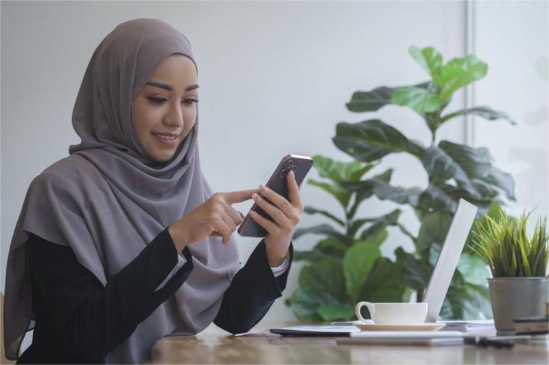 orang menggunakan laptop dan smartphone dengan latar peta digital
