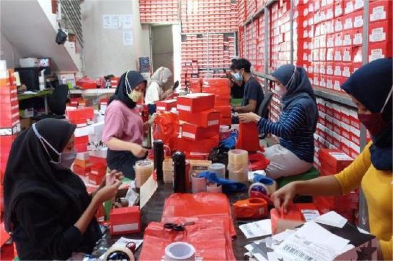 pelaku UMKM sedang memproses pesanan online di gudang kecil