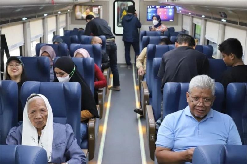 lansia tersenyum sambil memegang tiket gratis kereta jarak jauh dari KAI