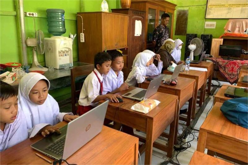 siswa menggunakan laptop dan smartphone belajar literasi digital di kelas