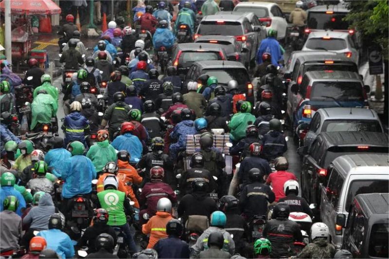 kemacetan parah di jalan utama Jakarta dengan kendaraan tak bergerak dan wajah-wajah lelah pengguna jalan