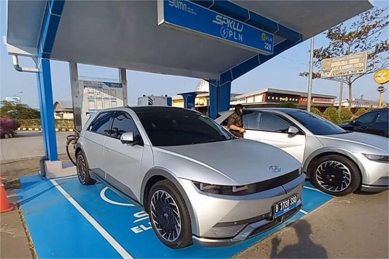 mobil listrik sedang mengisi daya di stasiun pengisian umum