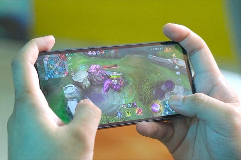 gamer muda serius bermain game mobile dengan perangkat smartphone