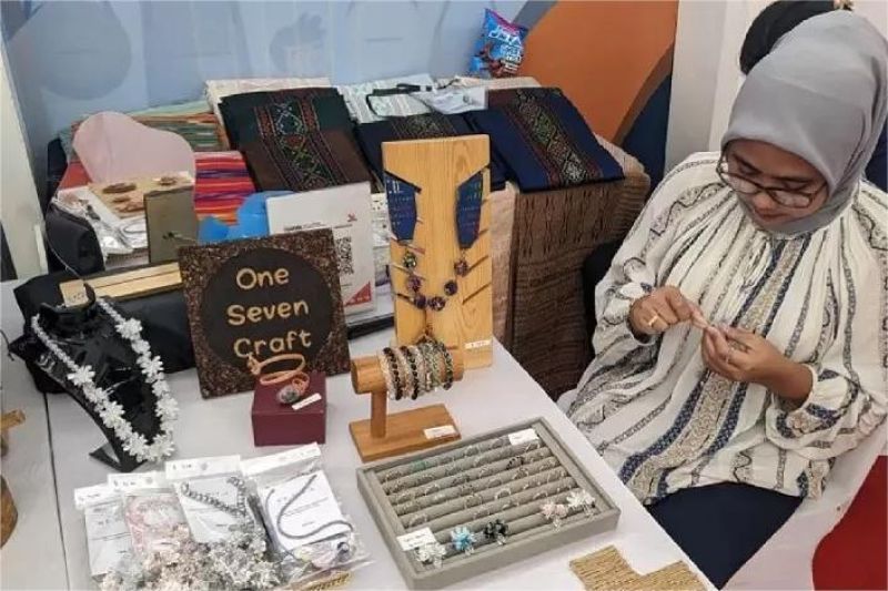pelaku UMKM sedang mengemas produk kerajinan tangan