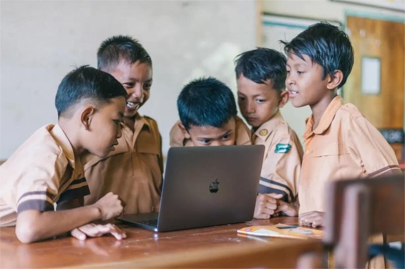 guru mengajar dengan menggunakan perangkat digital di kelas sekolah