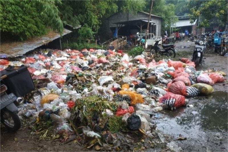 tumpukan sampah plastik di pinggir sungai perkotaan