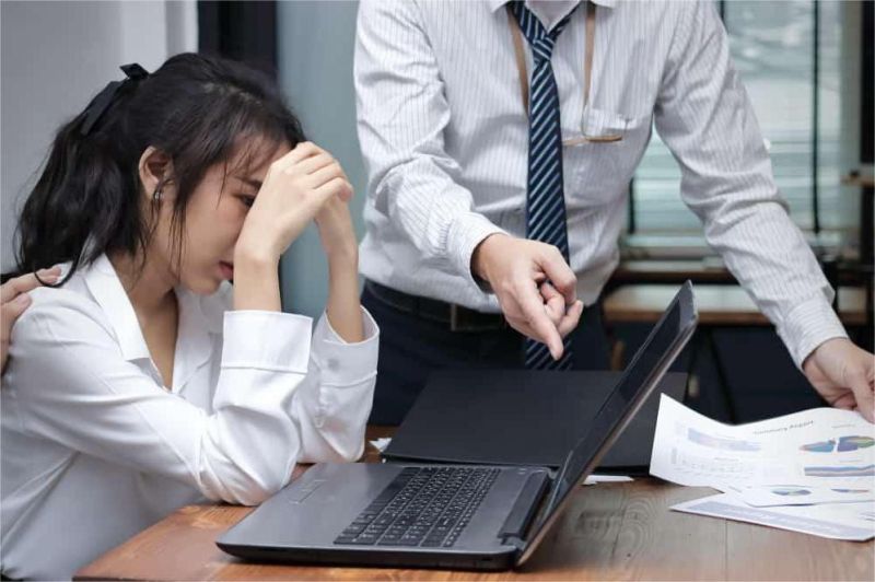 pekerja muda duduk stres di depan laptop di kantor