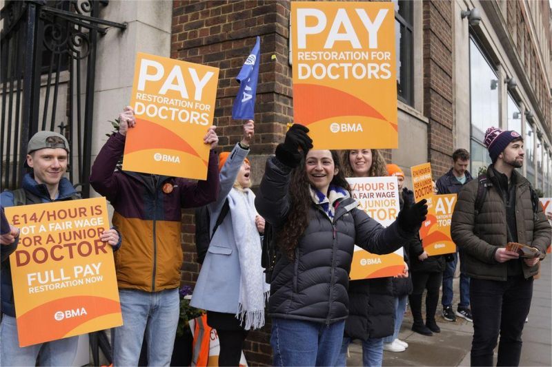 aksi mogok dokter di Inggris dengan membawa spanduk protes di depan parlemen London