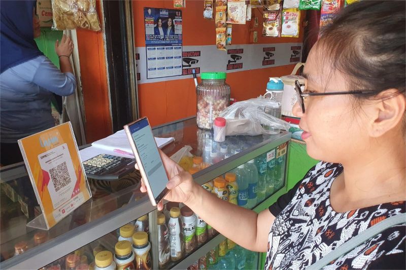 pelaku UMKM sedang melayani pelanggan di toko kecilnya