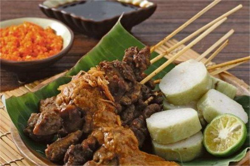 ilustrasi sate madura dengan bumbu kacang kental dan potongan lontong