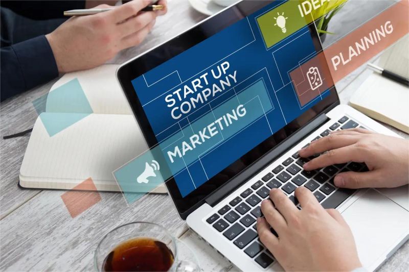 tim startup Indonesia sedang diskusi sambil menatap layar laptop