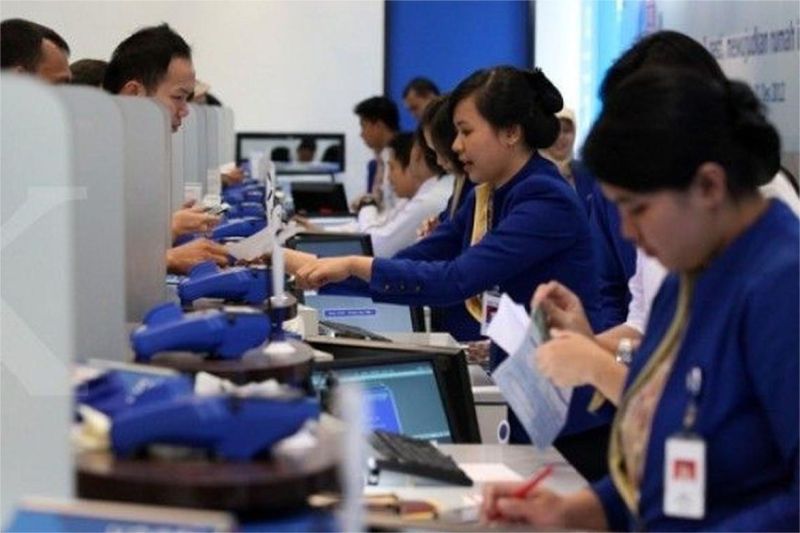 ilustrasi teller BCA melayani nasabah di kantor cabang bank