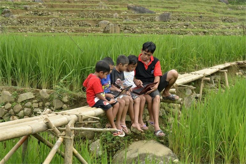 ilustrasi warga desa menggunakan internet melalui perangkat digital di area pedesaan dengan latar alam terpencil
