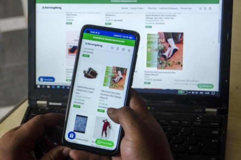 pelaku UMKM menggunakan laptop dan smartphone untuk bisnis digital