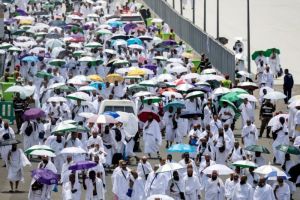 Para jemaah haji membawa payung untuk melindungi dari terik matahari, tiba di pemondokan jemaah, tenda Mina, di tengah pelaksanaan ibadah Haji di dekat Makkah, Jumat, 14 Juni 2024.
