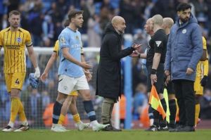 Pelatih Manchester City, Pep Guardiola berbicara dengan wasit Simon Hooper setelah laga melawan Brighton di Etihad Stadium. (c) AP Photo/Ian Hodgson