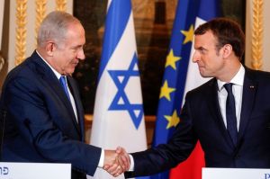 Perdana Menteri Israel Benjamin Netanyahu dan Presiden Prancis Emmanuel Macron berjabat tangan saat jumpa pers bersama setelah pertemuan mereka di Istana Elysee di Paris, Perancis, Minggu (10/11/2017)