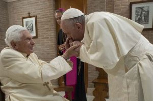 Paus Fransiskus mencium tangan mantan Paus Benediktus XVI dalam kunjungan setelah pelantikan 13 kardinal baru di Vatikan, pada Sabtu, 28 November 2020.(Vatican Media via AP)