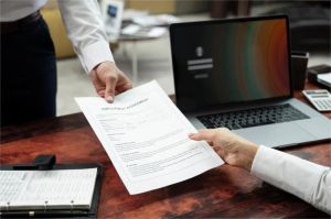 calon pelamar kerja sedang mempersiapkan dokumen lamaran kerja online di depan laptop